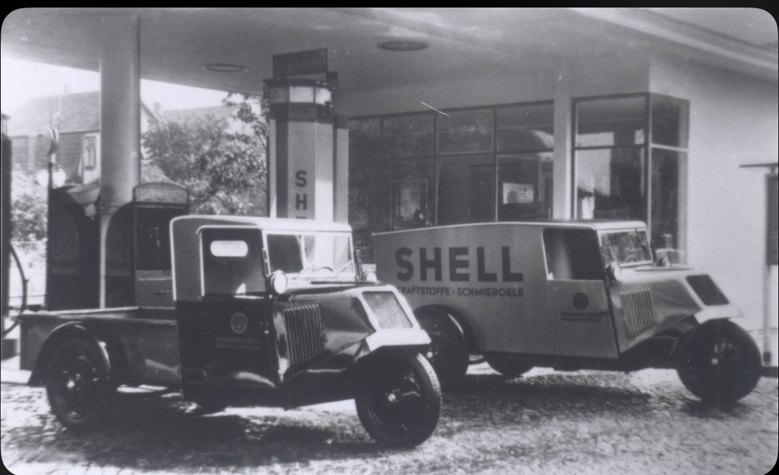 Historische Aufnahme zweier Tempo Front-Dreiradlieferwagen an einer Shell-Tankstelle